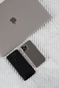Kaboompics - Close-Up of Black and Silver Smartphones Beside Laptop on White Textured Surface