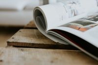Kaboompics - Open Magazine Curled on a Wooden Table, Neutral Interior Reading Still Life