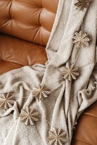 Kaboompics - Beige Blanket with Wooden Snowflake Ornaments on Sofa