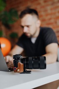 Kaboompics - DSLR Camera on Desk with Photographer Working in Background