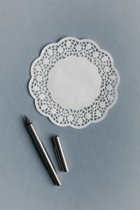 Kaboompics - Fountain Pen Beside Decorative Paper Doily Mockup