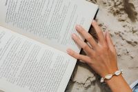 Kaboompics - Hand Turning Pages on a Beach Book, Summer Reading Detail