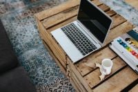 Kaboompics - Silver laptop and a white mug on a wooden box table