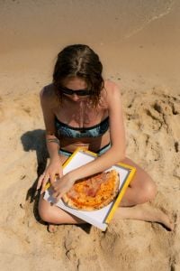 Kaboompics - Woman Holding a Pizza Box on a Sunny Beach