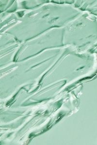 Kaboompics - Skincare Aesthetic Flowing Transparent Gel Macro Texture on Soft Green Background
