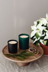 Kaboompics - Two Lit Candles with White Poinsettia, Evergreen and Dried Orange on a Rustic Wooden Tray, Neutral Christmas Decor Still Life