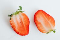 Kaboompics - Two Fresh Strawberry Halves on White, Red Fruit Cross Section for Food Blog and Recipe Design