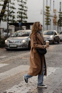 Kaboompics - Woman Crossing a Cobblestone Street with Takeaway Coffee