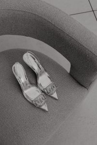Kaboompics - Ivory Spiral-Ankle Heels Draped over a Black Wire Chair
