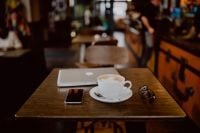 Kaboompics - Cup of coffee & MacBook laptop, iPhone mobile phone on table in cafe