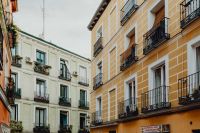 Kaboompics - Narrow Madrid Street Framed by Yellow and White Apartment Facades with Iron Balconies