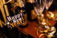 Kaboompics - Close-Up Happy New Year Champagne Tag and Flute Against Glittering Gold Decor
