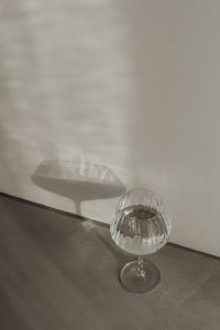 Kaboompics - Wine Glass Beside Its Oversized Ribbed Shadow on a Gray Wall