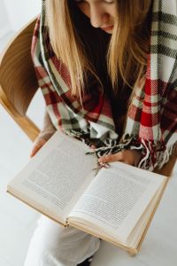 Kaboompics - Woman Reading a Book in a Cozy Chair