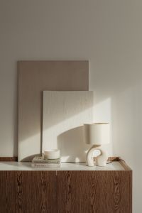 Kaboompics - Minimalist Lamp, Coffee Cup and Books on a Sunlit Neutral Sideboard