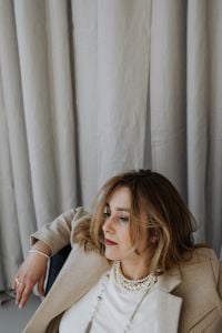 Kaboompics - Seated Portrait of Woman in Beige Blazer and Layered Pearls