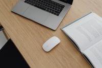 Kaboompics - Laptop, White Mouse And Open Book On Wooden Desk
