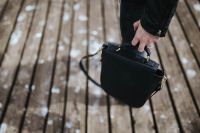 Kaboompics - Woman with a black bag walking on a wooden pier