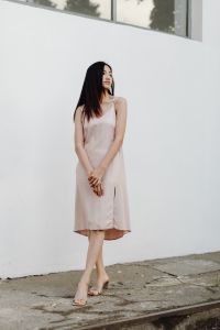 Kaboompics - Asian Fashion Model in Pale Dress Looking Up against White Architecture