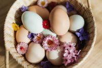 Kaboompics - Pastel Blue and Natural Eggs in Wicker Basket with Spring Flowers for Easter Decor