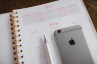 Kaboompics - Close-Up Pink Calendar Page with Smartphone and Silver Pen, Soft-Focus Stationery