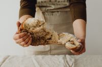 Kaboompics - Woman Tearing Fresh Bread in Half