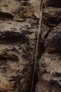 Kaboompics - Delicate Gold Chain Necklace on Dark Rock Close-Up