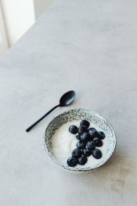 Kaboompics - Yogurt and Blueberries with Black Spoon on Gray Table