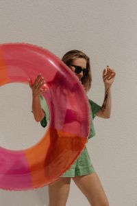Kaboompics - Woman Holding a Pink Inflatable Ring in Green Beachwear