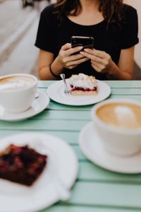 Kaboompics - The girl is using the phone in the cafeteria