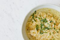 Kaboompics - Close-Up of Polish Rosół with Egg Noodles and Parsley, White Marble Copy Space