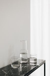 Minimal Glass Carafe and Water Glasses on a Black Marble Console