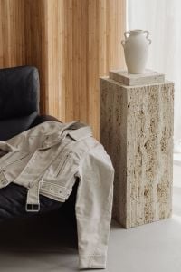Kaboompics - Beige Jacket on a Black Leather Sofa by a Travertine Pedestal