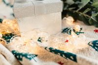 Kaboompics - White Gift Box and Festive Lights on a Patterned Blanket