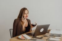 Kaboompics - Female Interior Designer Talking on Phone With Coffee and Laptop