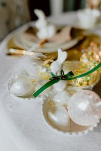 Kaboompics - White Bunny Figurine with Glass Easter Eggs, Green Ribbon and Soft White Feathers