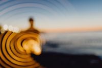 Kaboompics - Light painting. The man waving fairy lights at the sea at sunset.