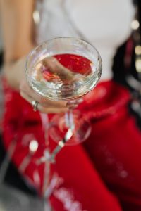 Kaboompics - Champagne Glass over Red Sequins and a Silver Streamer
