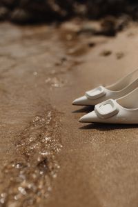 Kaboompics - White Pointed Pumps beside the Foamy Water’s Edge