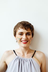 Kaboompics - Smiling Short-Haired Woman with Rainbow Cheek Paint and Copy Space