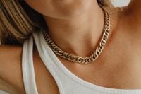 Kaboompics - Close-Up of a Gold Chain Necklace Styled with a White Asymmetric Top