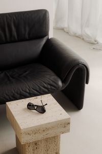 Kaboompics - Black Leather Sofa and Travertine Table with Sunglasses
