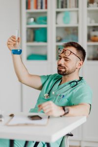Kaboompics - Doctor Inspecting Blue Laboratory Flask at Desk