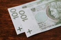 Kaboompics - Two Polish Zloty Banknotes on Dark Wood, Soft-Focus Finance Background