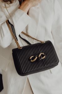 Kaboompics - Black Ribbed Evening Bag with Gold Chain and Linked Clasp, White Blazer