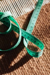 Kaboompics - Soft-Focus Green Measuring Tape on Striped and Textured Fabric