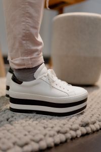 A woman in white flatform sneakers