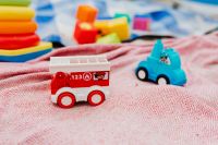 Kaboompics - Toy Fire Engine and Blue Car with Stacking Rings on a Pink Beach Blanket