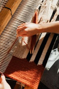 Kaboompics - Close-Up of Hand Weaving a Rust Colored Textile
