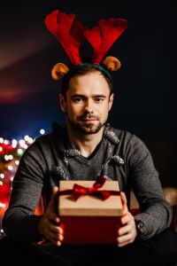 Kaboompics - Man Unwrapping Present with Red Ribbon at Christmas